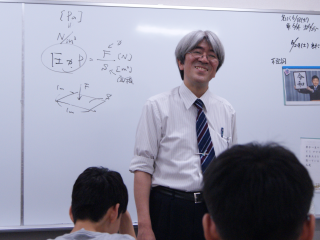 樋口先生が白板前で授業を行っている写真